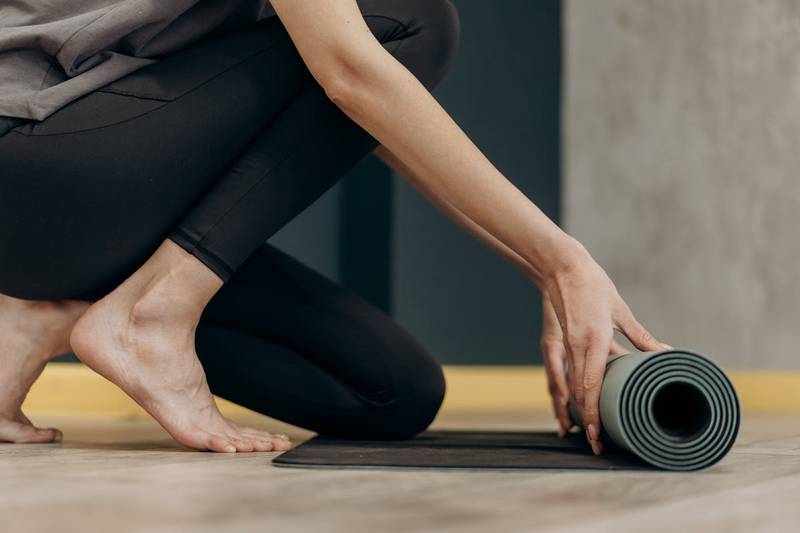 自宅筋トレ用のマットを広げる女性